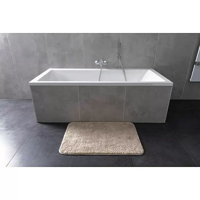 Camargue Badteppich Wuschel - 90 x 60 cm, Beige - Weiße rechteckige Badewanne mit grauer Fliesenverkleidung in modernem Badezimmer mit beigem Badteppich.