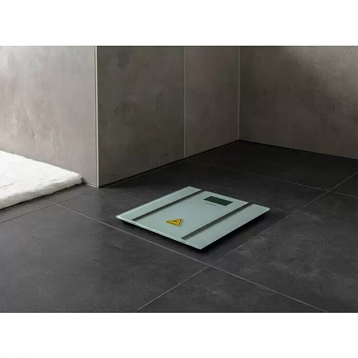Digitale Personenwaage BS-70E - 30 x 30 x 1,75 cm, Glas, Weiß - Glas-Badezimmerwaage mit silbernen Akzenten auf dunklem Fliesenboden, mit einem kleinen gelben Warnsymbol.
