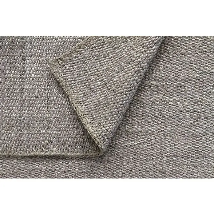 Alfombra de yute Córdoba - Gris, 230 x 160 cm, 100% yute - Primer plano de una alfombra tejida de color gris claro, destacando la textura y el borde detallado.