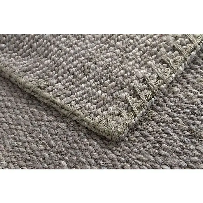 Alfombra de yute Córdoba - Gris, 230 x 160 cm, 100% yute - Primer plano de una alfombra gris-marrón con bordes anudados, destacando la textura y los detalles artesanales.