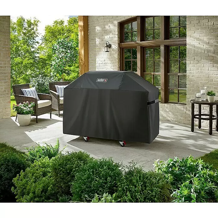 Weber Premium Grill-Schutzhülle - Passend für: Weber Genesis 300-Serie, Kunststoff - Schwarze Weber Grillabdeckung schützt einen Grill auf einer Außenterrasse.