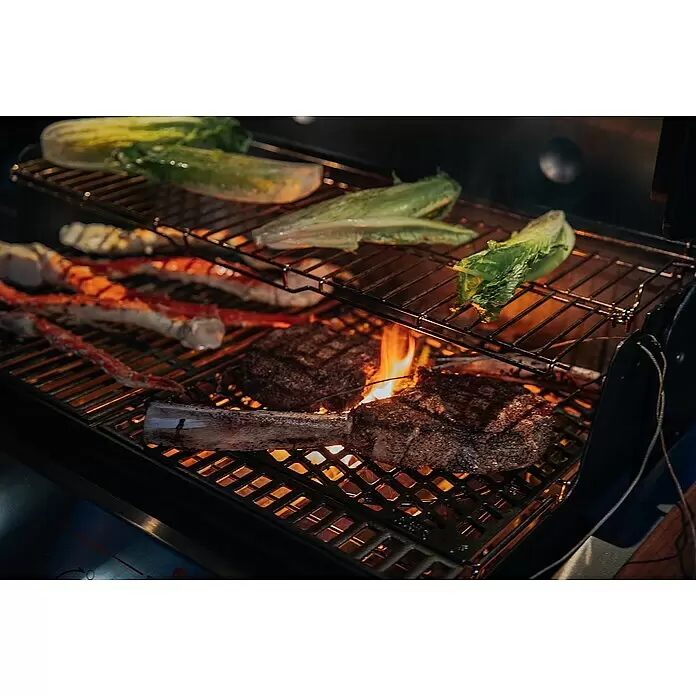 Weber Crafted Parrilla para barbacoa Sear Grate - L x An: 41,4 x 40,6 cm, Hierro fundido - Alimentos variados, incluyendo bistecs, patas de cangrejo y lechuga, asándose sobre llamas abiertas en una parrilla de metal.