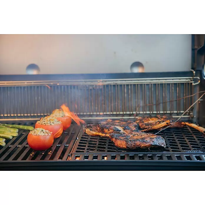 Weber Crafted Parrilla para barbacoa Sear Grate - L x An: 41,4 x 40,6 cm, Hierro fundido - Una parrilla de gas cocinando diversos alimentos como tomates rellenos, espárragos y grandes cortes de carne, con llamas visibles.