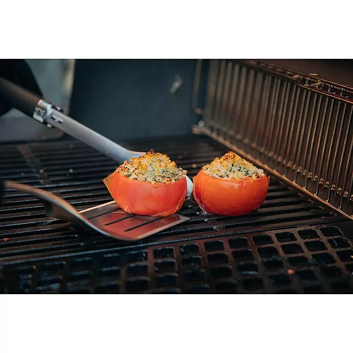 Weber Crafted Parrilla para barbacoa Sear Grate - L x An: 41,4 x 40,6 cm, Hierro fundido - Dos tomates rellenos con cobertura dorada cocinándose en una parrilla, junto a utensilios de barbacoa.