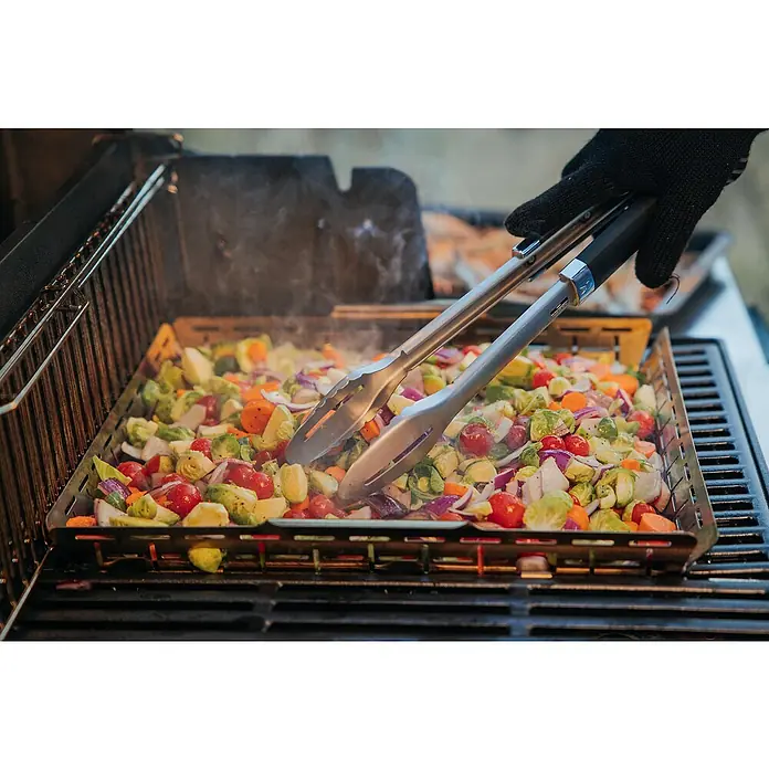 Weber Crafted Grillkorb - L x B x H: 41,4 x 43,7 x 5,1 cm, Edelstahl - Gemüse wie Rosenkohl und Tomaten werden mit einer Grillzange in einem Grillkorb auf einem Grill zubereitet, köstlich und gesund.