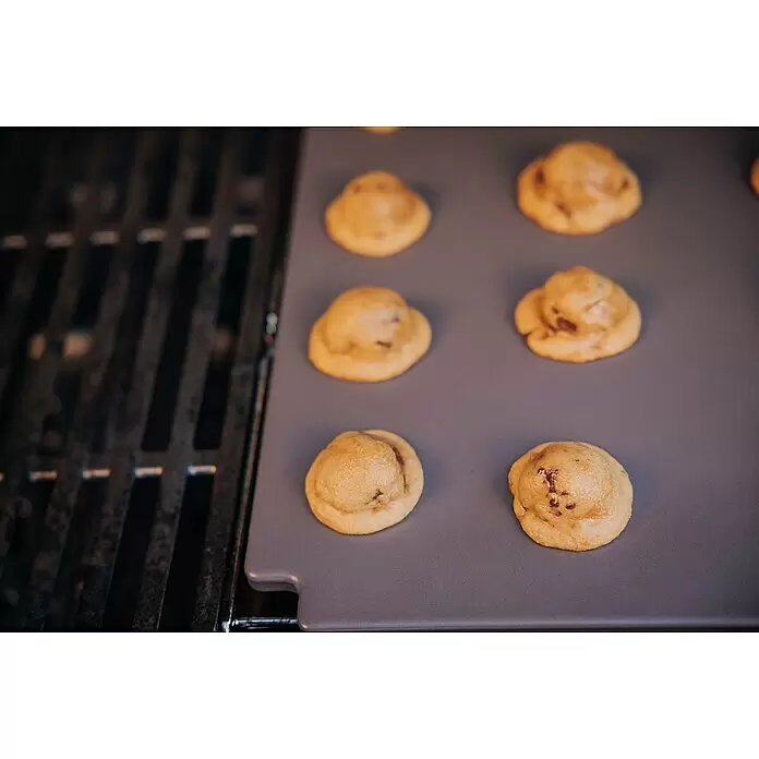 Weber Crafted Piedra para pizzas Esmaltado - L x An: 41,4 x 40,6 cm - Tapete de silicona gris para parrilla con varias galletas horneándose, junto a una rejilla de parrilla.