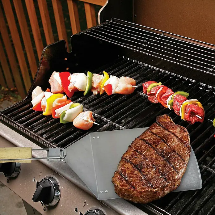 Jim Beam Grillgutwender - Länge: 54 cm - Gegrilltes Steak mit Gemüse-Schaschliks auf einem Grill. Das Steak liegt auf einem Grillwender.
