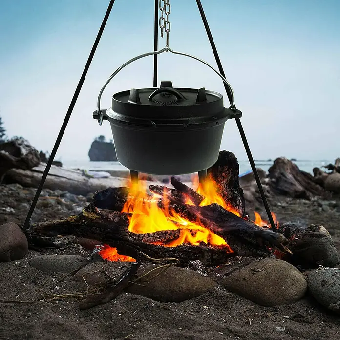 Jim Beam Dutch Oven - Ø x H: 27,2 x 19 cm - Schwarzer Dutch Oven hängt über einem Lagerfeuer, ideal zum Kochen im Freien. Robustes Kochgeschirr für Camping und Outdoor-Abenteuer.