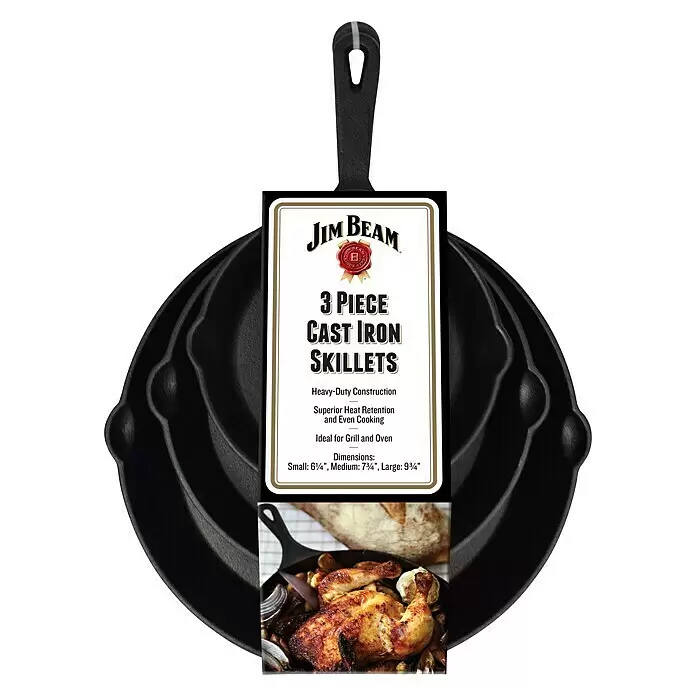 Jim Beam Pfannen-Set - 3 -tlg. - Drei schwarze Jim Beam Gusseisenpfannen, ineinander gestapelt, mit Produktetikett. Eine Pfanne zeigt gebratenes Huhn und Gemüse.