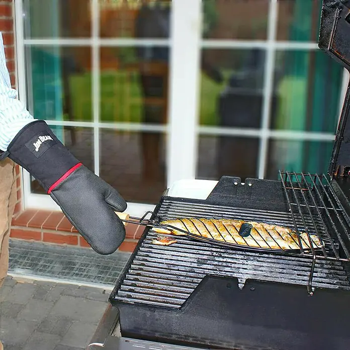 Jim Beam Fisch- & Gemüsehalter - Länge: 67 cm, 2 Stk. - Ein Mann grillt einen Fisch mit einem Grillhandschuh. Der Fisch liegt in einem Grillkorb auf dem Grill, perfekt für ein Outdoor-Kocherlebnis.