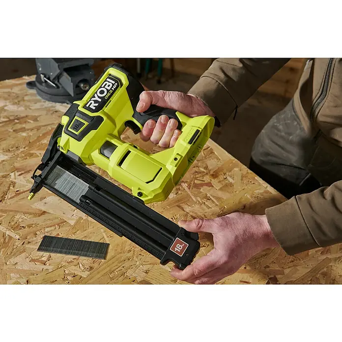 Ryobi ONE+ Maschinenpaket - Akku-Nagler R18GN18X-0 + gratis Starter-Kit - Das Ryobi ONE+ HP Akku-Nagelgerät mit Magazin und einer Ladung Nägel auf einer Werkbank.