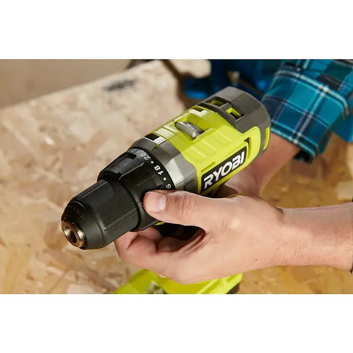 Ryobi ONE+ Akku-Bohrschrauber RDD18-2C20S - 18 V, 2 Akkus, 2 Ah, 52 Nm - Nahaufnahme eines Ryobi-Akkuschraubers, der von einer Person mit kariertem Hemd gehalten wird. Das Werkzeug ist bereit für den Einsatz.