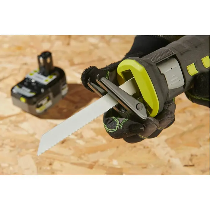 Ryobi ONE+ Akku-Säbelsäge RRS18-0 - 18 V - Nahaufnahme einer Ryobi Akku-Säbelsäge mit eingesetztem Sägeblatt, gehalten von einer Person mit Arbeitshandschuhen vor Holzhintergrund.