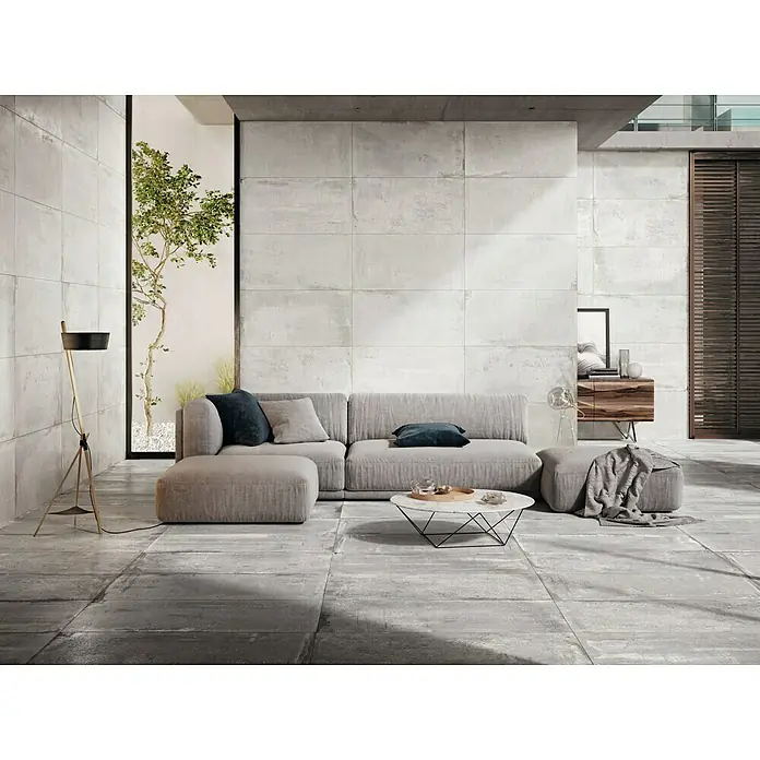 Feinsteinzeugfliese Bond - 60 x 120 cm, Weiß, Matt - Wohnzimmer mit grauen Bodenfliesen und passendem Sofa, minimalistisch und modern gestaltet für ein stilvolles Ambiente.