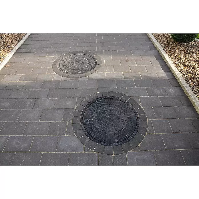 ACO Schachtdeckel SAKU - Durchmesser: 785 mm, Mit Lüftungsöffnung - Zwei dunkle, runde Kanaldeckel mit gemusterten Oberflächen in einem dunkelgrauen Pflasterweg.