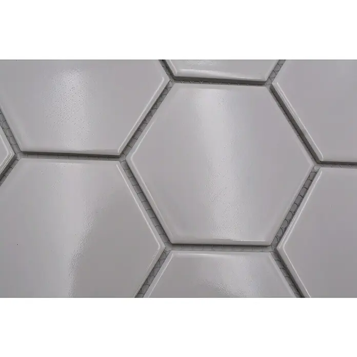 Mosaikfliese Hexagon Uni HX 100 - 25,6 x 29,55 cm, Weiß, Glänzend - Nahaufnahme von weißen, glänzenden Sechseckfliesen, die ein modernes und sauberes Design für Badezimmer oder Küchenrückwände bieten.