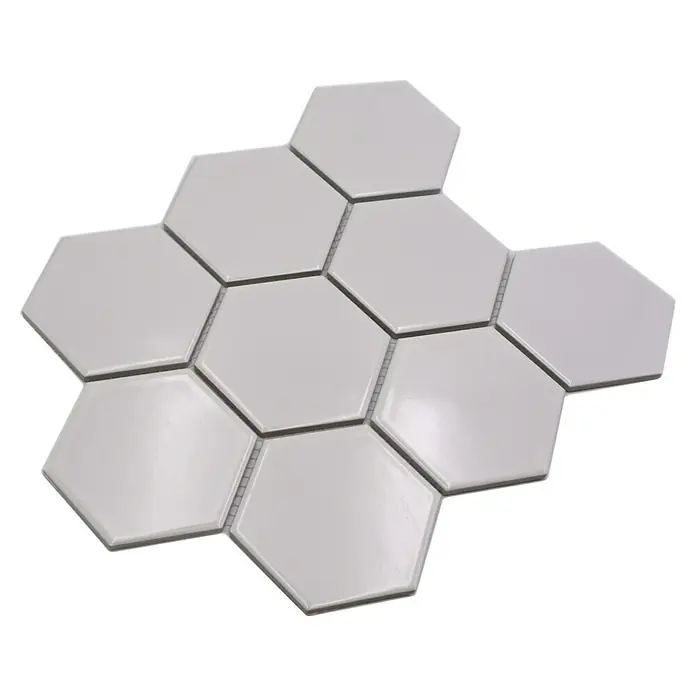 Mosaikfliese Hexagon Uni HX 100 - 25,6 x 29,55 cm, Weiß, Glänzend - Helle sechseckige Fliesen auf einer schwarzen Oberfläche, die ein sauberes und modernes Design ausstrahlen.