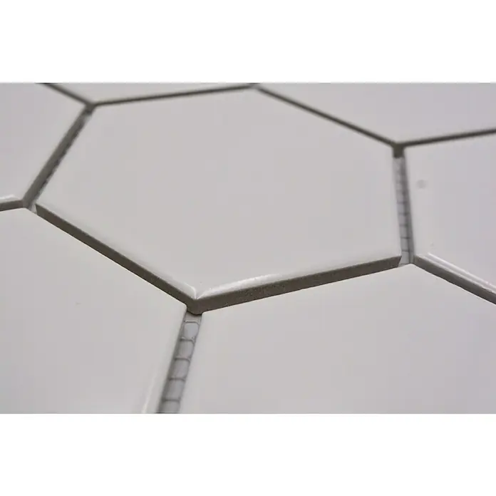 Mosaikfliese Hexagon Uni HX 100 - 25,6 x 29,55 cm, Weiß, Glänzend - Nahaufnahme von weißen, sechseckigen Fliesen mit grauen Fugenlinien, die ein sauberes und modernes Design präsentieren.