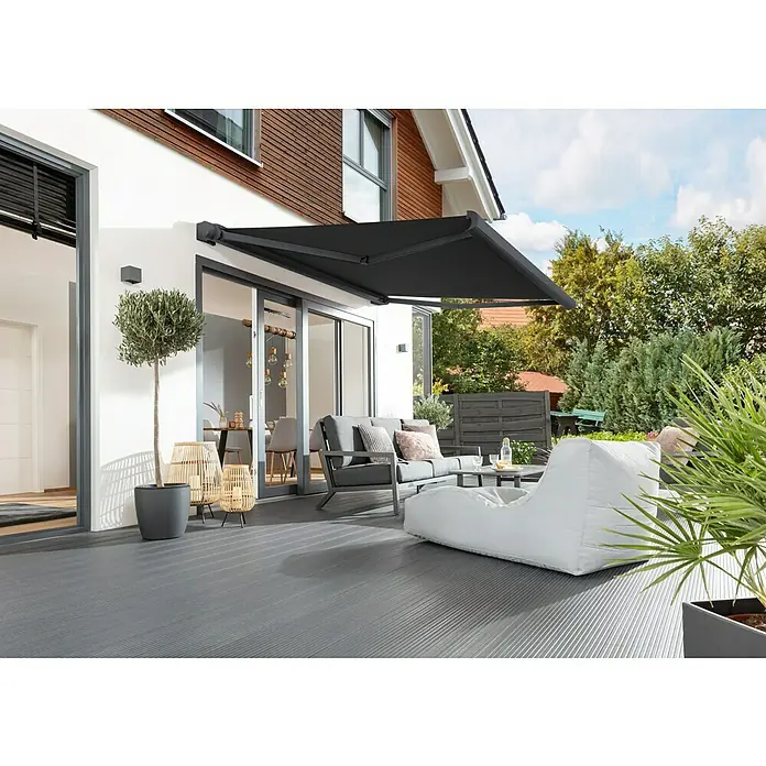 Sunfun Vollkassettenmarkise Elba - Schwarz, Farbe Gestell: Anthrazitgrau, Breite: 5 m, Ausfall: 3,5 m - Eine moderne Terrasse mit grauer Markise, stilvollen Gartenmöbeln und dekorativen Pflanzen.