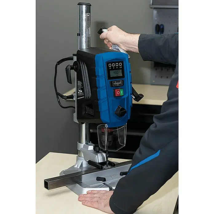 Scheppach Tischbohrmaschine DP 60 - 710 W, Leerlaufdrehzahl: 0 U/min - 2.600 U/min, Spannweite Bohrfutter: 1,5 mm - 13 mm - Der Scheppach Tischbohrer DP60, ein Werkzeug für präzise Bohrungen, wird von einer Person bedient, die ein Metallstück bearbeitet.