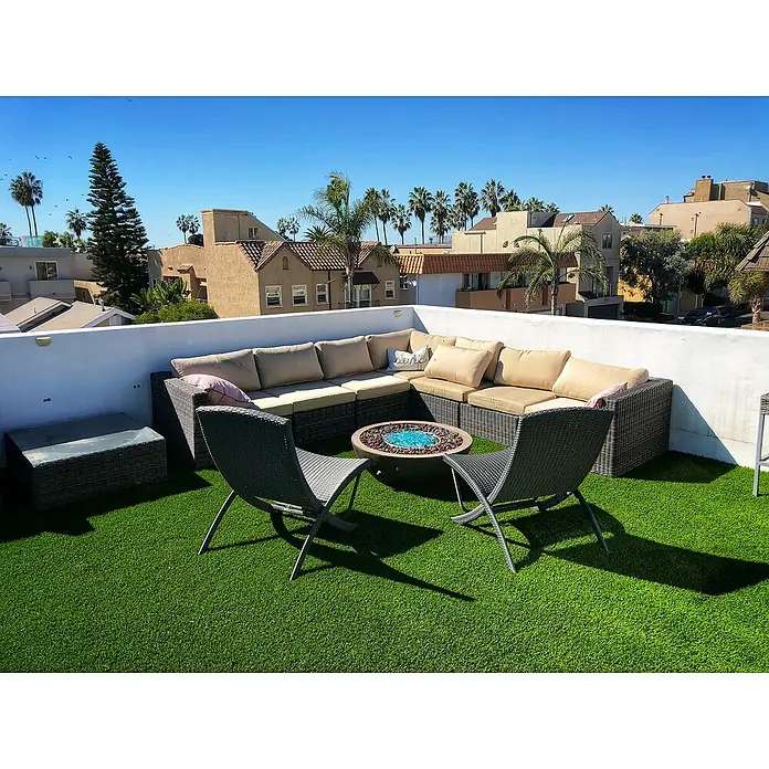 Césped artificial ECO - 5 x 2 m, Altura del pelo: 40 mm, 18.900 puntadas/m² - Relájese en la azotea con un sofá modular de exterior, una mesa de centro con piedras azules y dos sillas elegantes sobre césped artificial.