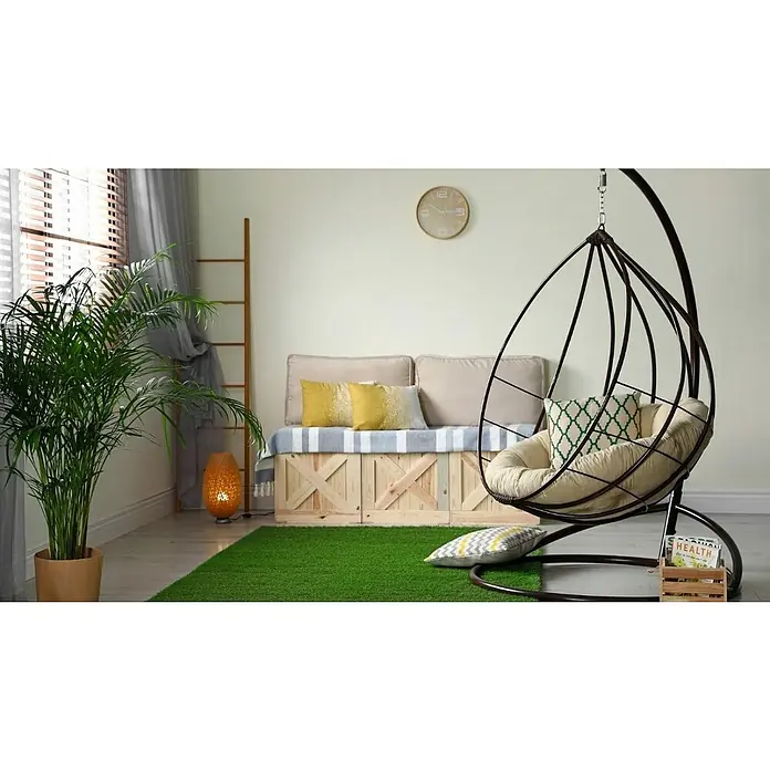 Césped artificial ECO - 5 x 2 m, Altura del pelo: 40 mm, 18.900 puntadas/m² - Acogedor espacio habitable con una silla colgante tipo cesta perfecta para la relajación, complementada con toques verdes e iluminación cálida.