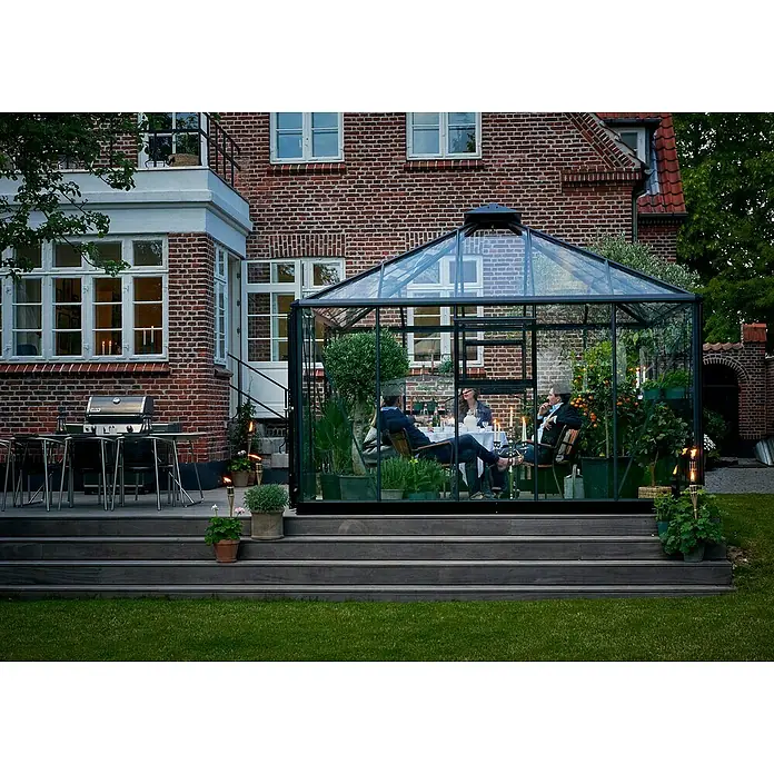 Juliana Gewächshaus Oase - Außenmaß inkl. Dachüberstand (B x T): 368 x 368 cm, Material Seitenwand: Glas, 3 mm, Anthrazit/Schwarz - Ein stilvolles Gewächshaus aus Glas und Stahl dient als Esszimmer im Freien. Elegante Gartengestaltung und einladende Atmosphäre.