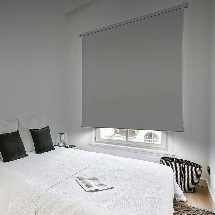 Estor enrollable opaco PP - An x Al: 150 x 180 cm, Gris - Persianas enrollables grises cubren la ventana de un dormitorio moderno, ofreciendo privacidad y oscuridad.