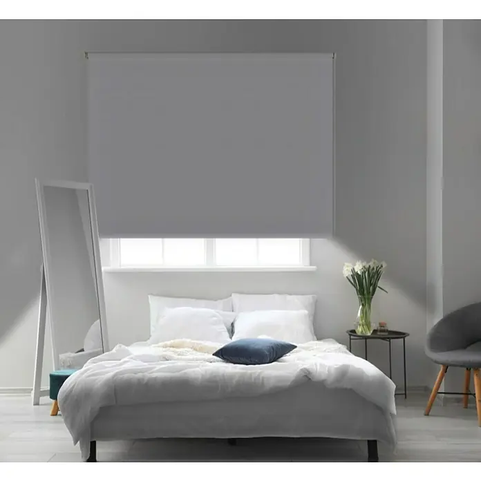 Estor enrollable opaco Night - An x Al: 100 x 180 cm, Blanco - Un dormitorio moderno con un gran estor gris en la ventana. El estor ofrece privacidad y control de la luz.