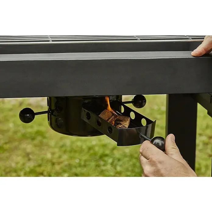 Barbacoa de carbón Easy 60 - Superficie de la parrilla (An x Pr): 57 x 30 cm, Negro - Primer plano de la parrilla de carbón con fuego y mano operando el regulador de aire.