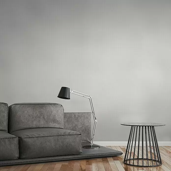 A.S. Création Trendwall 2 Vliestapete - Reinweiß, Uni, 10,05 x 0,53 m - Graues Modulsofa, silberne Stehlampe und schwarzer Metallbeistelltisch in modernem Wohnzimmer.