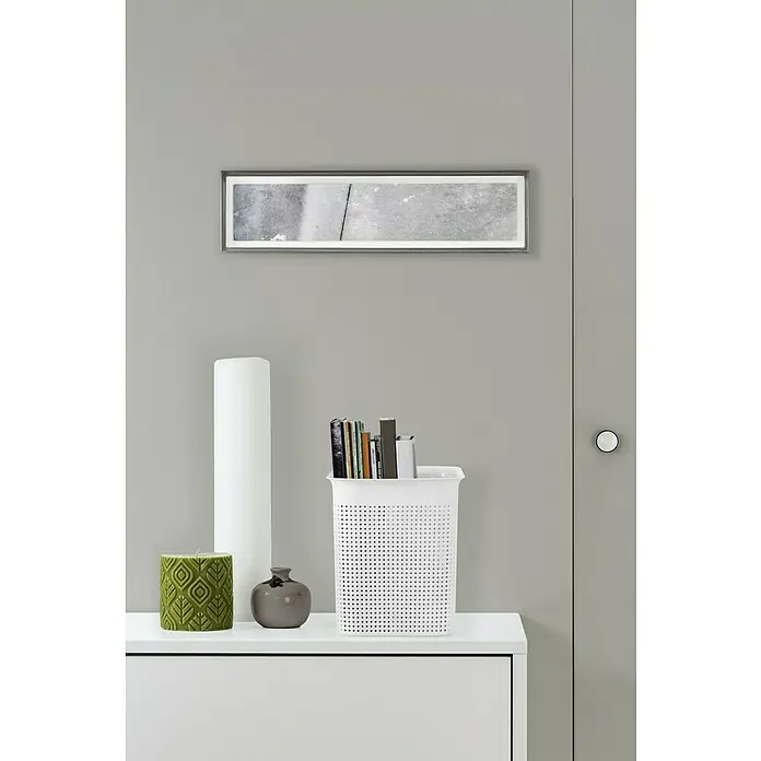 Rotho Aufbewahrungsbox Brisen - L x B x H: 26,2 x 18 x 21,1 cm, Kunststoff, Weiß - Dekoratives Interieur mit Bücherkorb: Ein stilvoller Bücherkorb auf einer Kommode, neben Kerze und Vase, unter einem modernen Wandbild.