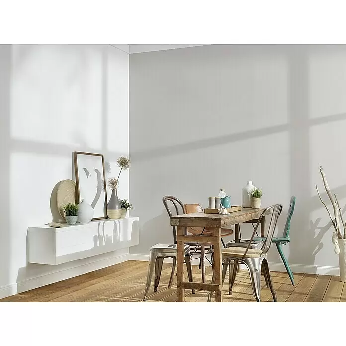 A.S. Création Trendwall 2 Vliestapete - Grau, Uni, 10,05 x 0,53 m - Ein eklektisches Esszimmer-Set mit einem rustikalen Holztisch und verschiedenen Metall- und Holzstühlen in einem hellen, modernen Raum.