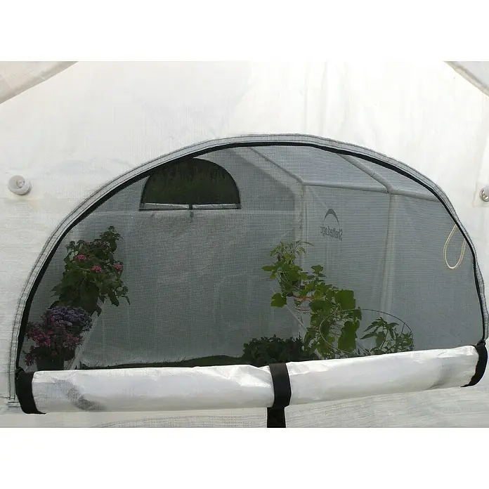 ShelterLogic Folien-Gewächshaus - 240 x 180 x 200 cm, Aluminium - Nahaufnahme eines Gewächshausfensters mit Netz und Pflanzen. Ideal für Gärtner und Pflanzenliebhaber, schützt das Gewächshaus.