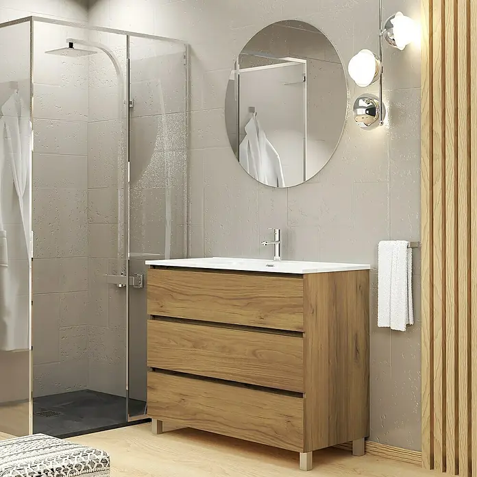 Artysan Conjunto de mueble de baño Basic 3C - Ancho: 90 cm, Ancho total del mueble de baño: 90 cm, Roble waira, 3 pzs. - Un baño moderno con un mueble de madera con tres cajones, un espejo redondo y una ducha con mampara.