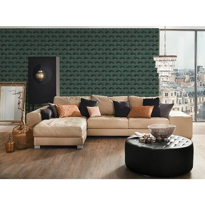 A.S. Création Titanium 3 Vliestapete 3D-Effekt - Grün/Gold, 3D-Optik, 10,05 x 0,53 m - Helle Ledercouch mit Zierkissen vor einer gemusterten Wand und einem Fenster mit Stadtblick. Eine elegante Wohnzimmergestaltung.