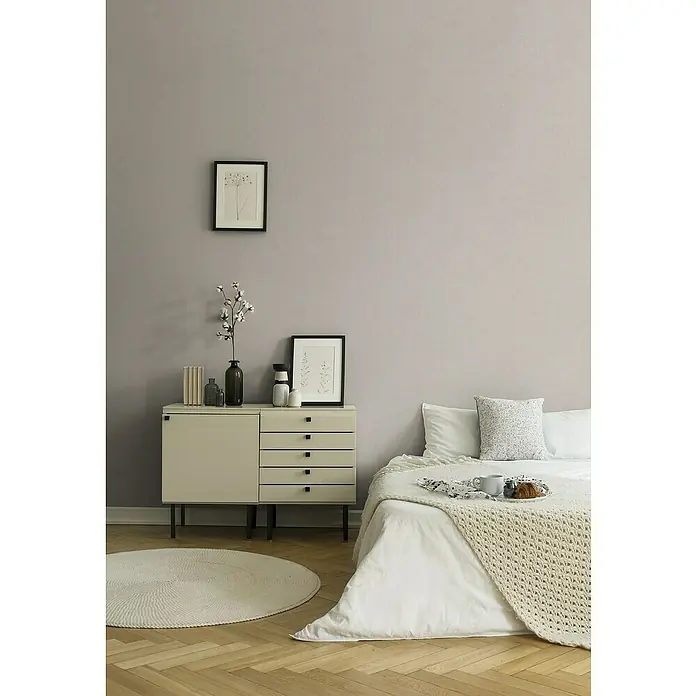 A.S. Création Titanium 3 Vliestapete - Grau/Weiß, Uni, 10,05 x 0,53 m - Einladendes Schlafzimmer mit stilvoller Kommode, sanften Textilien und hellen Farben, die eine ruhige Atmosphäre schaffen.