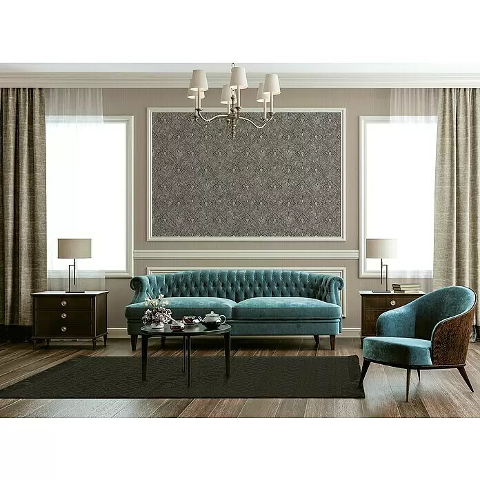 A.S. Création Mata Hari Vliestapete Oriental - Beige/Grau, Grafisch, 10,05 x 0,53 m - Dunkler Teppich mit dezentem geometrischem Muster, der ein luxuriöses Wohnzimmer mit einem türkisen Sofa und Sesseln erdet.