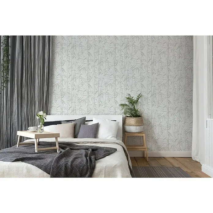 A.S. Création Michalsky 4 Vliestapete Bambus - Beige/Creme, Floral, 10,05 x 0,53 m - Schlafzimmer mit Bett, Tablett, Blumen und einer Pflanze. Die Wand ist mit Bambusmotiven tapeziert.