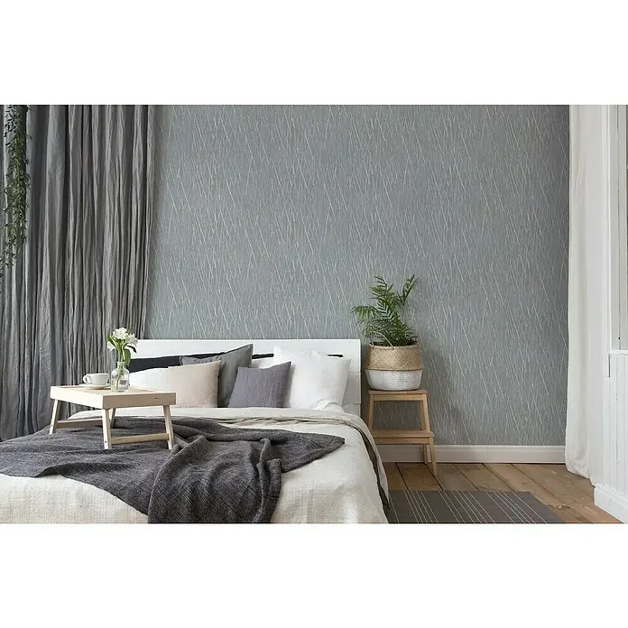 A.S. Création Hygge 2 Vliestapete Crush - Mittelgrau/Silber, Grafisch, 10,05 x 0,53 m - Schlafzimmer mit grauem Hintergrund und bequemen Bett. Die graue Tagesdecke und die Kissen laden zum Entspannen ein.