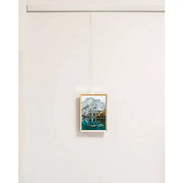 Nielsen Alurahmen Pixel - 13 x 18 cm, Gold - Bilderschienensystem, das einen hellen Holzrahmen mit einem Druck an einem dünnen Draht aufhängt.