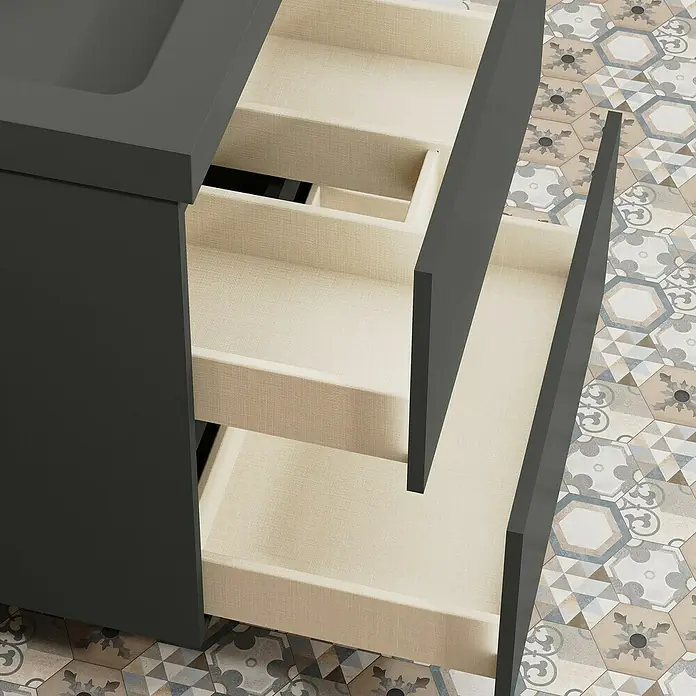 Artysan Conjunto de mueble de baño Kenia - Ancho: 60 cm, Ancho total del mueble de baño: 60 cm, Antracita, Mate, 2 pzs. - Un primer plano de un moderno armario de baño con cajones abiertos que revelan un inserto de tela beige, sobre un suelo de baldosas estampadas.