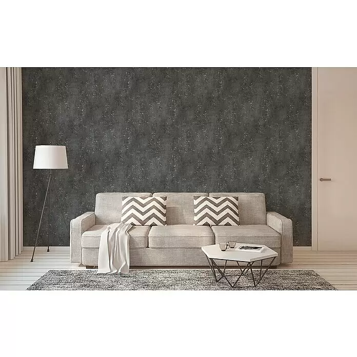 A.S. Création Titanium 3 Vliestapete I - Schwarz, Betonoptik, 10,05 x 0,53 m - Dunkelgraue Tapete mit hellen Sprenkeln, die eine moderne, strukturierte Kulisse in einem Wohnzimmer bietet.