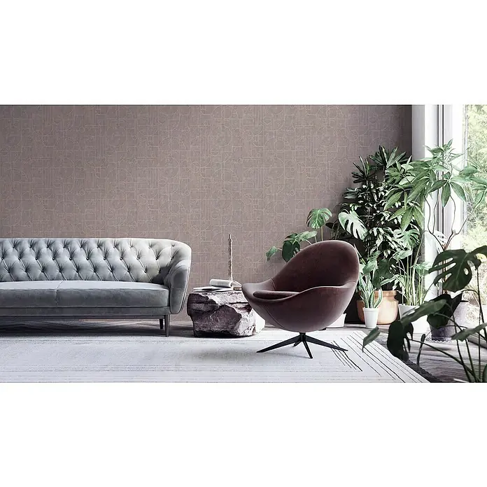 A.S. Création My Home My Spa Vliestapete Art Deco - Taupe, Grafisch, 10,05 x 0,53 m - Ein elegantes Wohnzimmer mit einem grauen Chesterfield-Sofa und einem braunen Sessel, ergänzt durch Zimmerpflanzen und einem modernen Teppich.