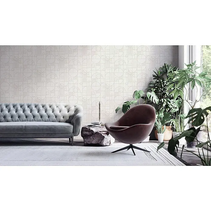 A.S. Création My Home My Spa Vliestapete Art Deco - Creme, Grafisch, 10,05 x 0,53 m - Wohnzimmer mit grauem Sofa, Sessel und Pflanzen. Die Wand hat ein geometrisches Muster.