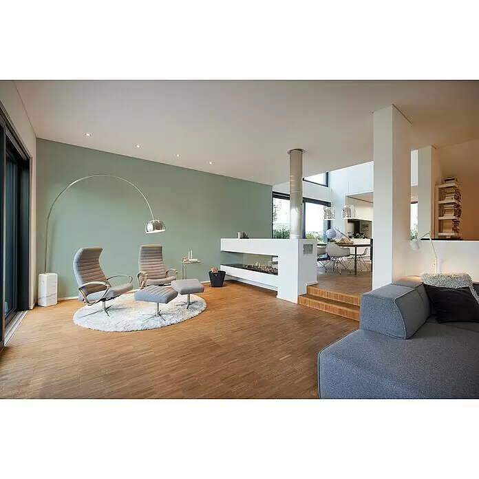 A.S. Création My Home My Spa Vliestapete Textstruktur I - Grün, Uni, 10,05 x 0,53 m - Moderne graue Polstersessel und Hocker auf einem weißen Teppich, neben hellem Holzparkettboden.