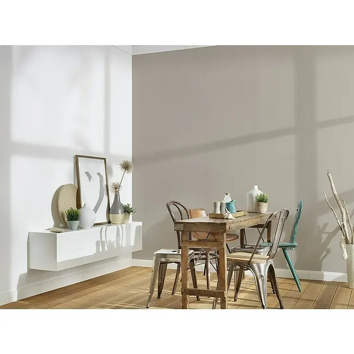 A.S. Création Mata Hari Vliestapete - Beige/Braun, Uni, 10,05 x 0,53 m - Ein Esszimmer mit einem Holztisch und verschiedenen Stühlen, ergänzt durch eine schwebende Anrichte mit dekorativen Elementen.