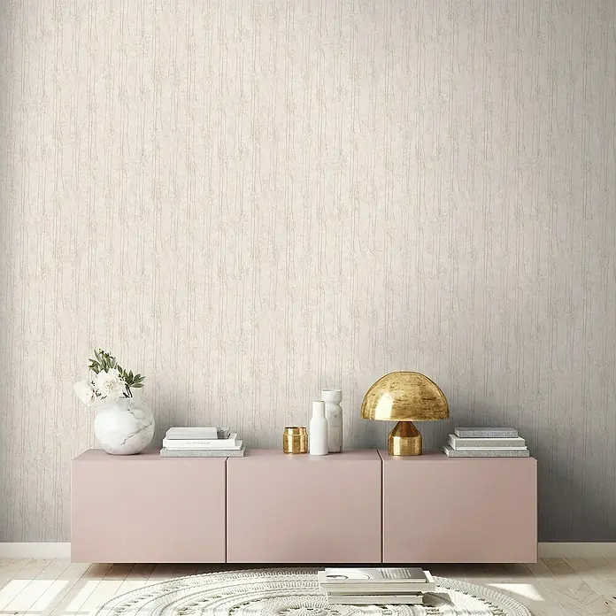 A.S. Création Hygge 2 Vliestapete Bäume - Helltaupe, Floral, 10,05 x 0,53 m - Dekorative Nahaufnahme einer rosa Kommode mit Wohnaccessoires, die eine stilvolle und gemütliche Atmosphäre im Raum schafft.