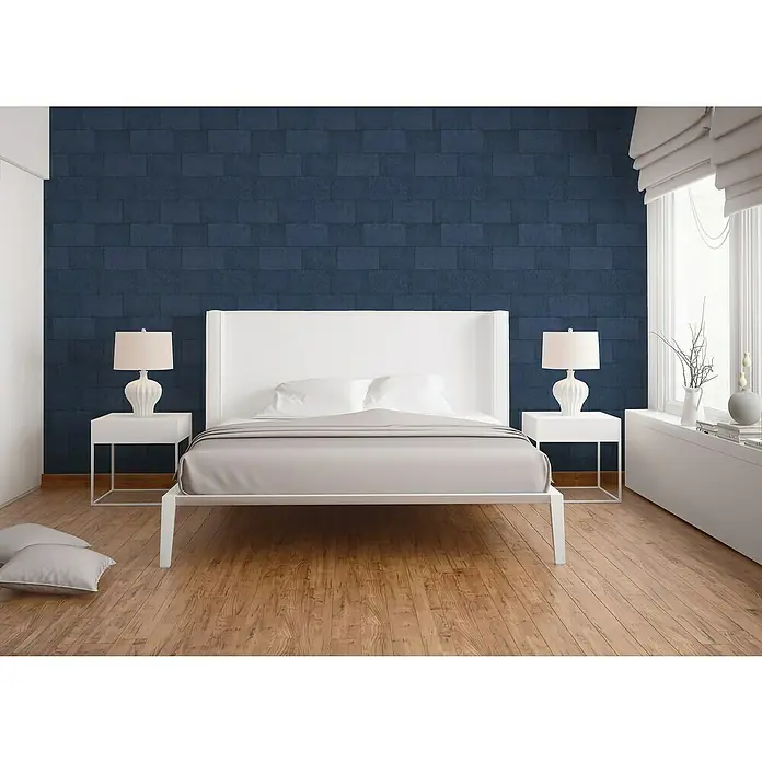 A.S. Création Titanium 3 Vliestapete - Blau, Steinoptik, 10,05 x 0,53 m - Ein modernes Schlafzimmer mit einem stilvollen weißen Bettgestell, Nachttischen und Lampen vor einer blauen Backsteinmauer.