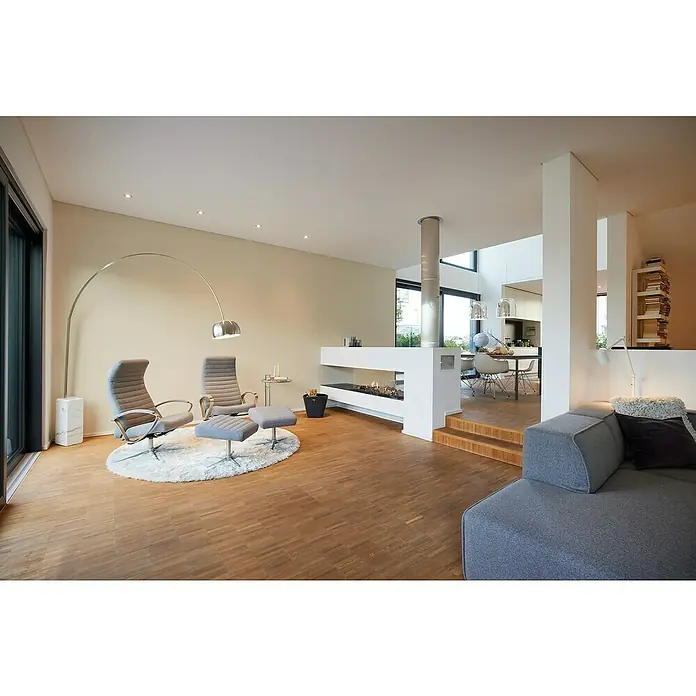 A.S. Création My Home My Spa Vliestapete Textilstruktur II - Creme, Uni, 10,05 x 0,53 m - Helles Wohnzimmer mit zwei grauen Sesseln und Fußhockern unter einer Bogenlampe auf einem flauschigen Teppich. Moderner Wohnraum mit Kamin.